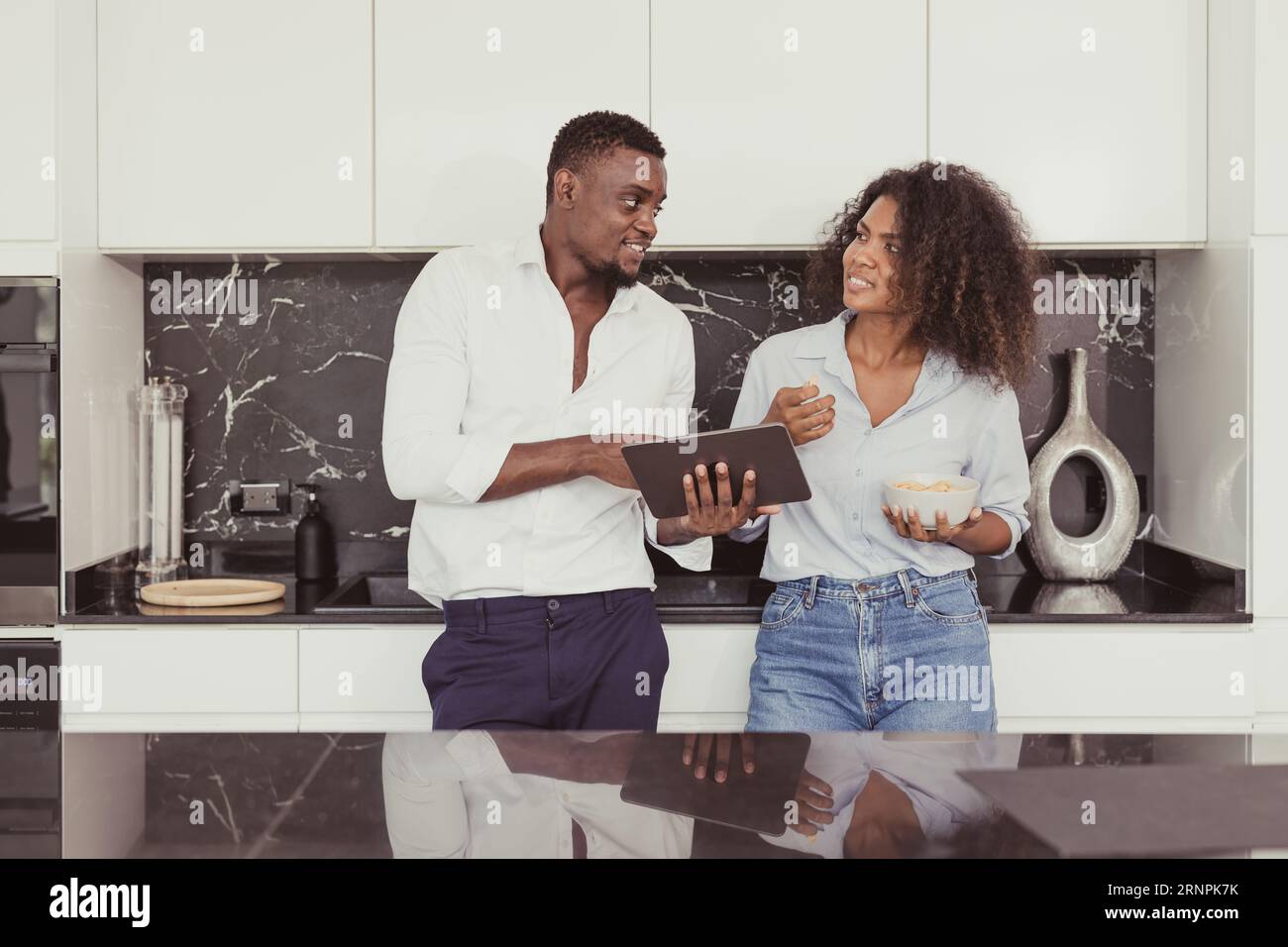Black People Pärchen Familie miteinander reden Business Consult Entspannen Sie sich in der Küche Zuhause Vintage Farbtöne Stockfoto