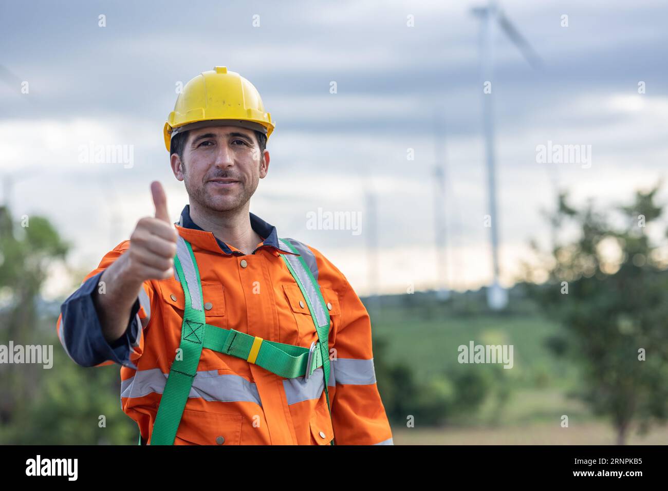 Porträtingenieur, männlicher Arbeiter mit Schutzhelm, der für seine Arbeit mit lächelnden Daumen nach oben steht Stockfoto