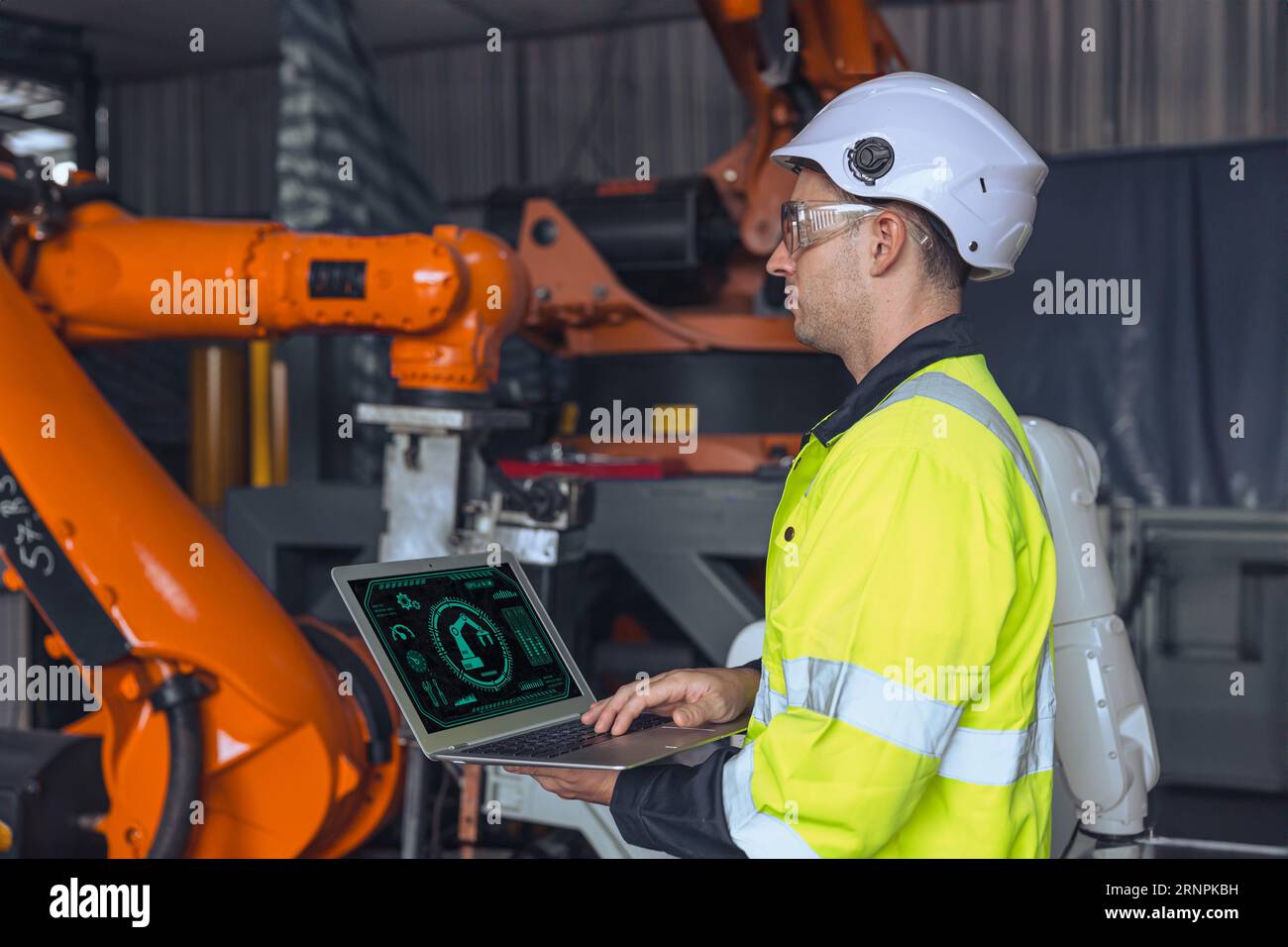 Ingenieur männlich mit Laptop-Computer-Steuerung bedienen Industrie-Roboter Arm Maschine. Man programmiert den Prüfservice für den Schweißroboter Stockfoto