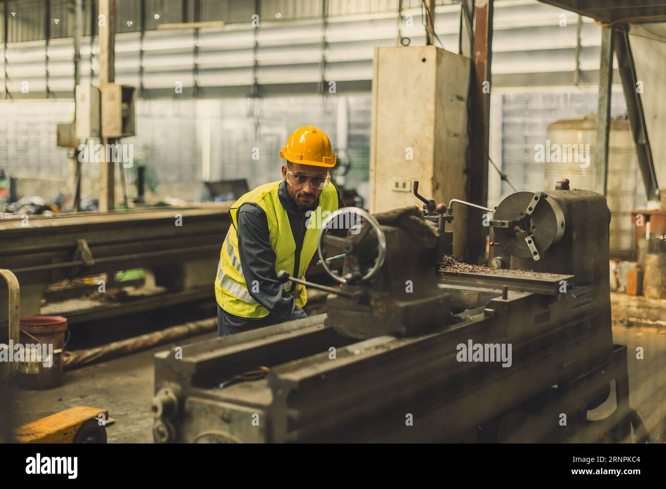 Hispanischer lateinischer indischer professioneller Techniker, der mit einer Präzisionsfräsmaschine aus Stahl in einer Drehmetallfabrik arbeitet Stockfoto