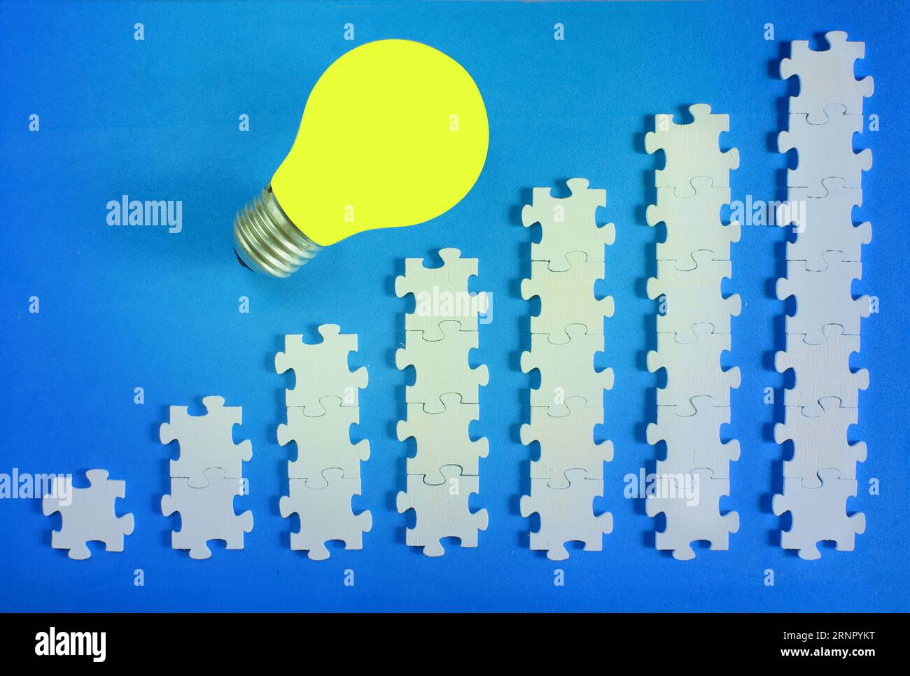 Geschäftskonzept, Geld verdienen, Ideen, Innovation, Personalwesen, Rekrutierung, Teamaufbau und Erfolg mit Puzzleteilen und Glühbirne Stockfoto