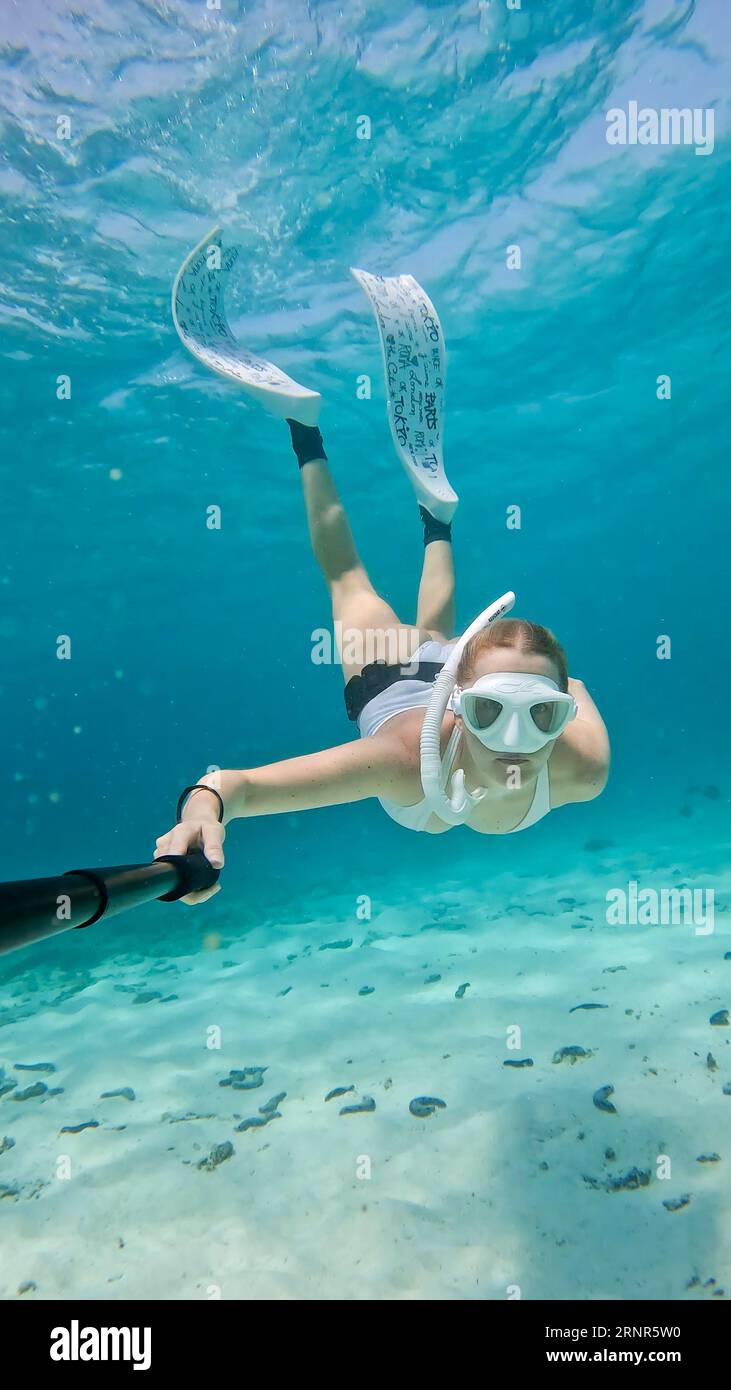 Weibliche Schnorchlerin, die unter Wasser in türkisfarbenem Wasser schwimmt. Stockfoto