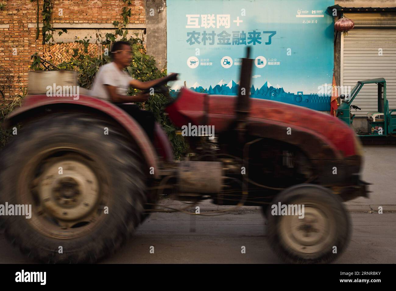 (170925) -- PEKING, 25. September 2017 -- Ein Traktor passiert Ein Brett mit dem Charakter Internet Plus im Dorf Liulin von Youfang Town im Qinghe County, Xingtai Stadt in der nordchinesischen Provinz Hebei, 19. September 2017. Die Leute können den QR-Code scannen, um ihm das Geld zu bezahlen. China unternahm stetige Schritte, um seinen Internet Plus-Aktionsplan umzusetzen und das Internet in traditionelle Industrien zu integrieren. Mit der schnellen Entwicklung des mobilen Internets schuf die Kampagne auch einen neuen Motor für das ländliche Wirtschaftswachstum in Dörfern wie Liulin. Dorfbewohner in Liulin Village, einem kleinen Dorf etwa 400 km vom n entfernt Stockfoto