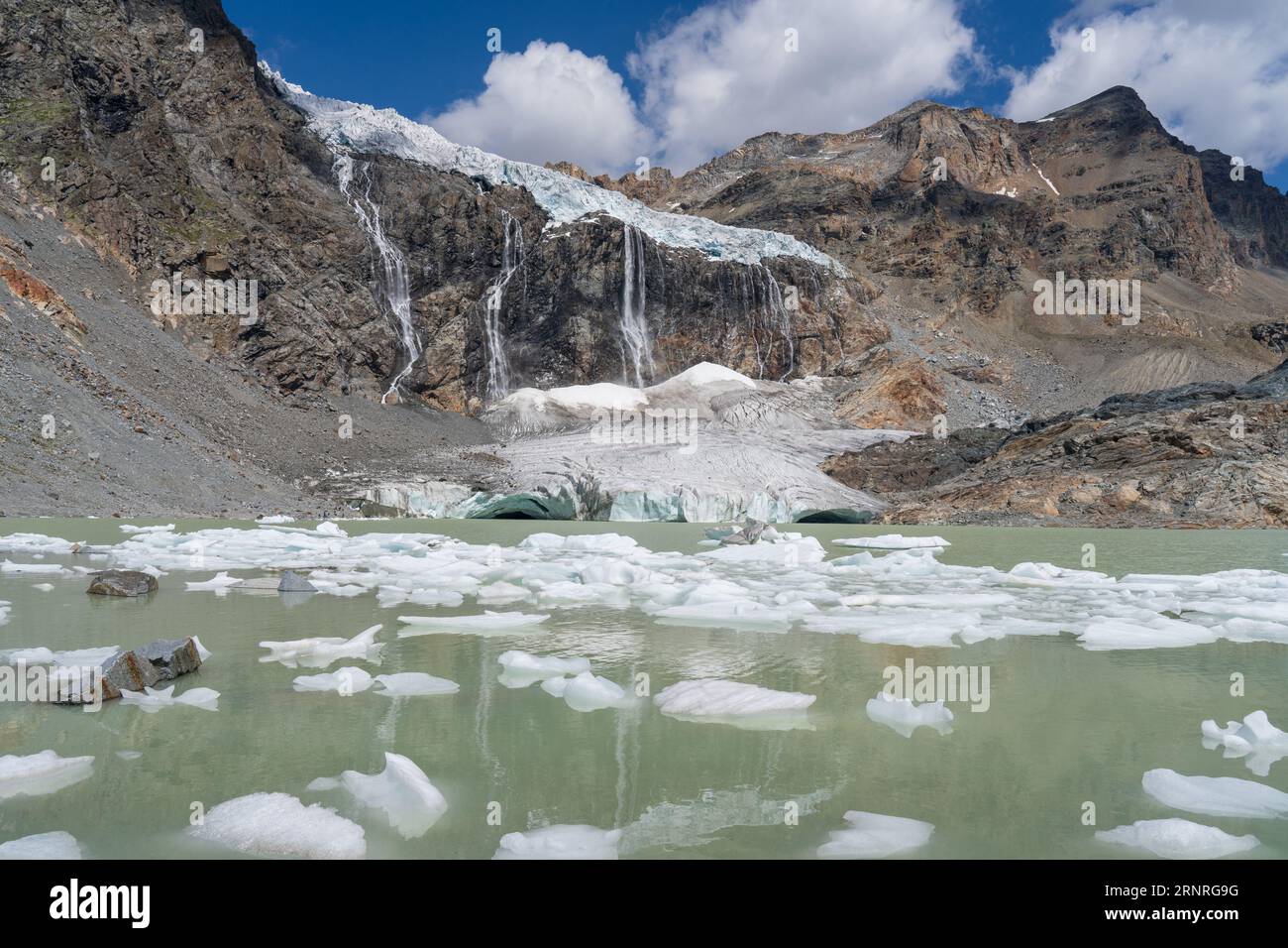 Schmelzender Gletscher in der Berglandschaft, hoher Wasserfall und See (Fellaria-Gletscher, Valmalenco, italienische Alpen). Globale Erwärmung und Klimawandel. Stockfoto
