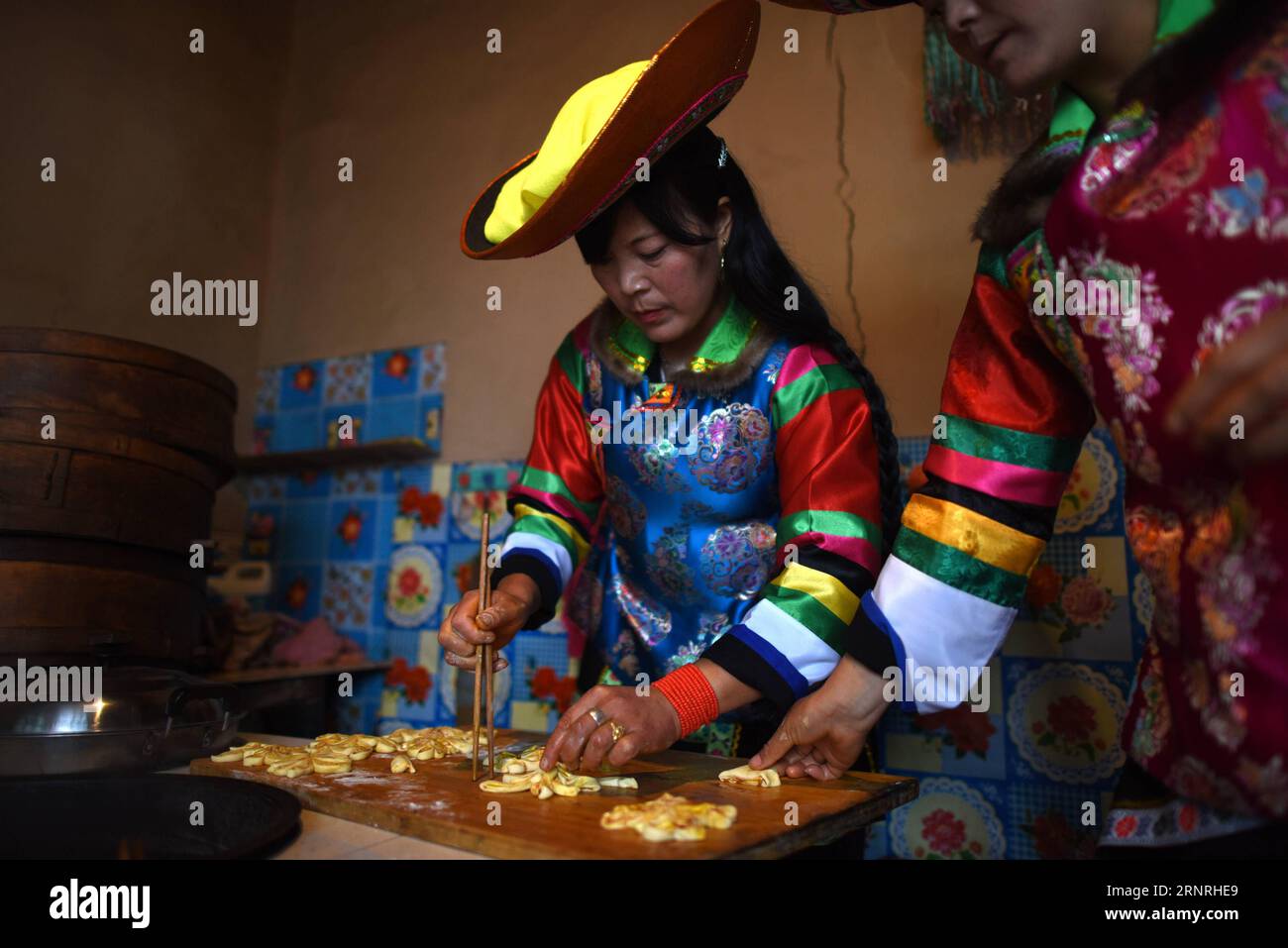 (171002) -- HAIDONG, 2. Okt. 2017 -- Suo Zhanxiang (L) macht Teigblumen, um einen großen Mondkuchen im Suobutan Village des autonomen Bezirks Huzhu Tu in Haidong, Provinz Qinghai im Nordwesten Chinas, 2. Okt. 2017 zu schmücken. Der spezielle Mondkuchen ist ein traditionelles Essen der Tu-Ethnie anlässlich des Mid-Autumn Festivals, das am 4. Oktober dieses Jahres stattfindet. ) (Ry) CHINA-MID-HERBSTFESTIVAL-VORBEREITUNGEN (CN) ZhangxHongxiang PUBLICATIONxNOTxINxCHN Stockfoto