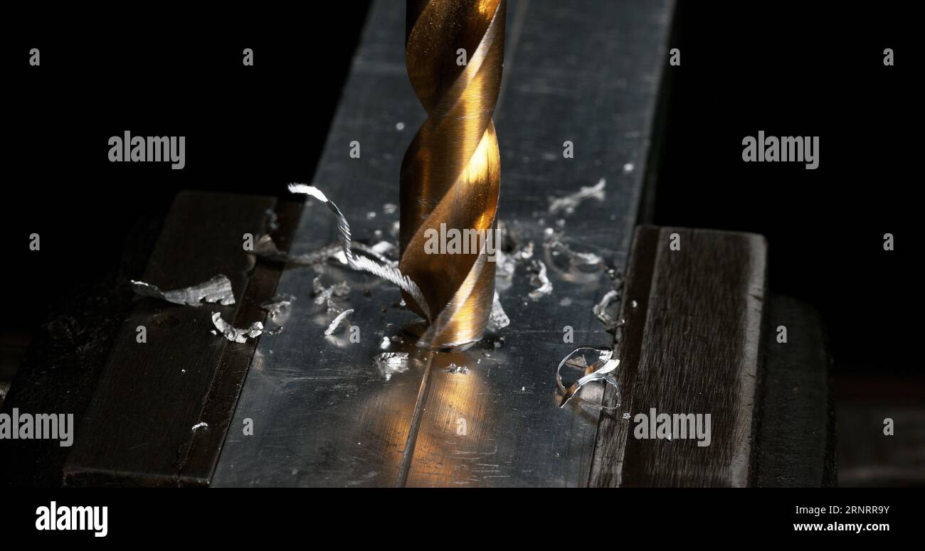 Metallbohrer Drehen auf einer Stahlplatte, die Chips herstellt Stockfoto