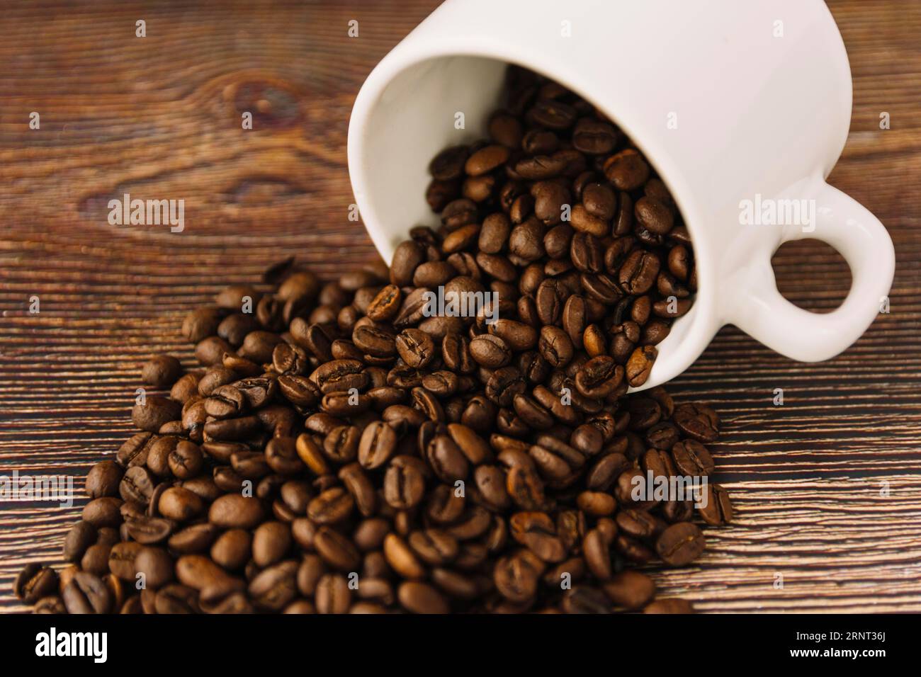 Aus der Tasse streuende Kaffeekörner Stockfoto