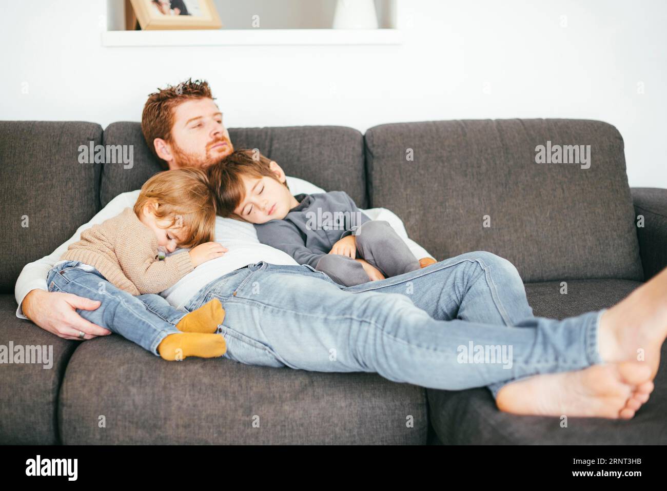 Dad schläft mit Sons Sofa Stockfoto