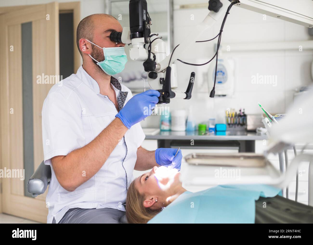Männlicher Zahnarzt zur Behandlung einer Wurzelkanalpatientin Stockfoto