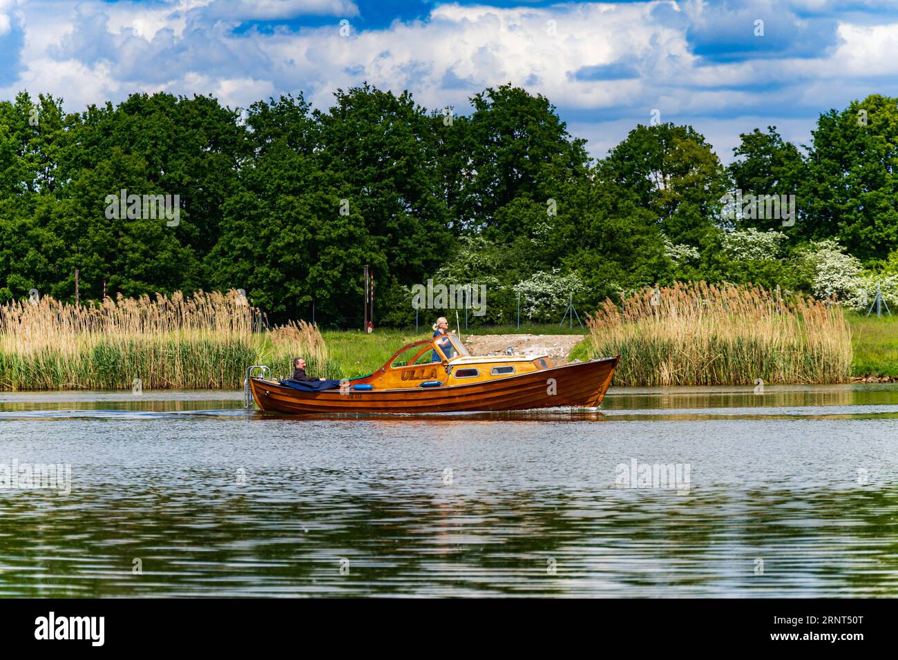 Wroclaw, Polen - 14. Mai 2023: Wunderschönes großes Holzboot namens Ulla, das langsam an der oder neben der Küste vor großen Büschen und grünen Bäumen fließt Stockfoto