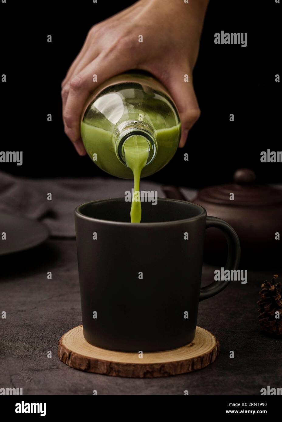 Vorderansicht, handausgießende Matcha-Teetasse Stockfoto