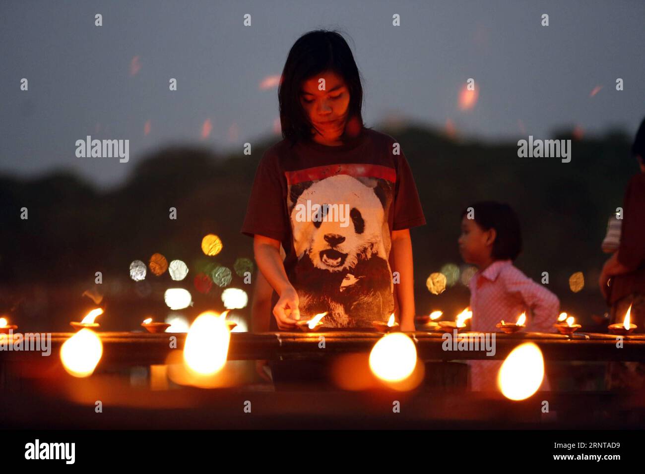 (171103) -- YANGON, 3. November 2017 -- Ein Mädchen zündet Öllampen während des Tazaungdaing-Festivals in Yangon, Myanmar, am 3. November 2017 an. Das Tazaungdaing-Festival findet im achten Monat des Kalenderjahres Myanmars statt, um das Ende der Regenzeit zu markieren. ) MYANMAR-YANGON-TAZAUNGDAING FESTIVAL UxAung PUBLICATIONxNOTxINxCHN Stockfoto
