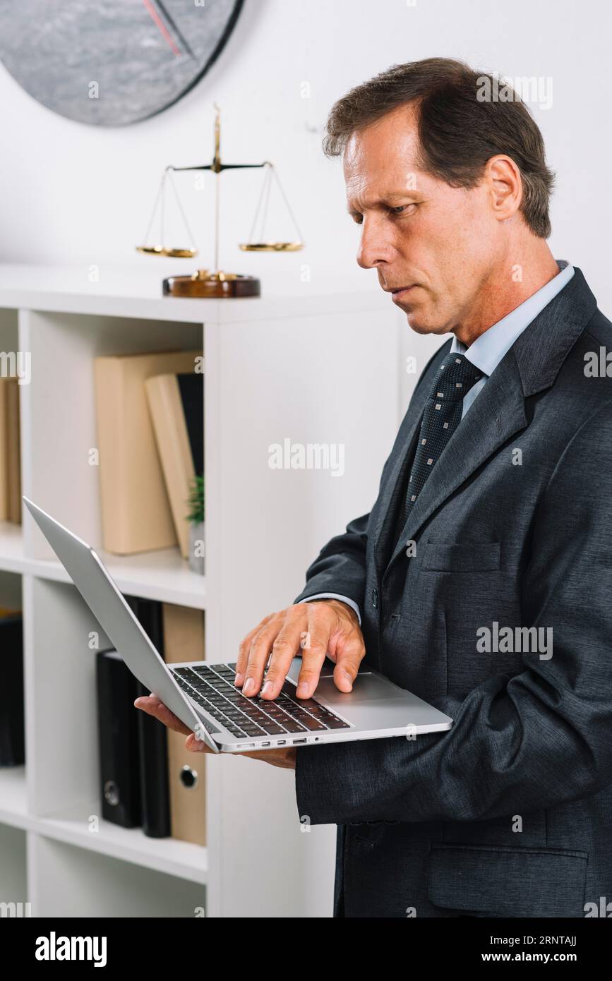 Porträtreife männliche Anwältin mit Laptop Stockfoto