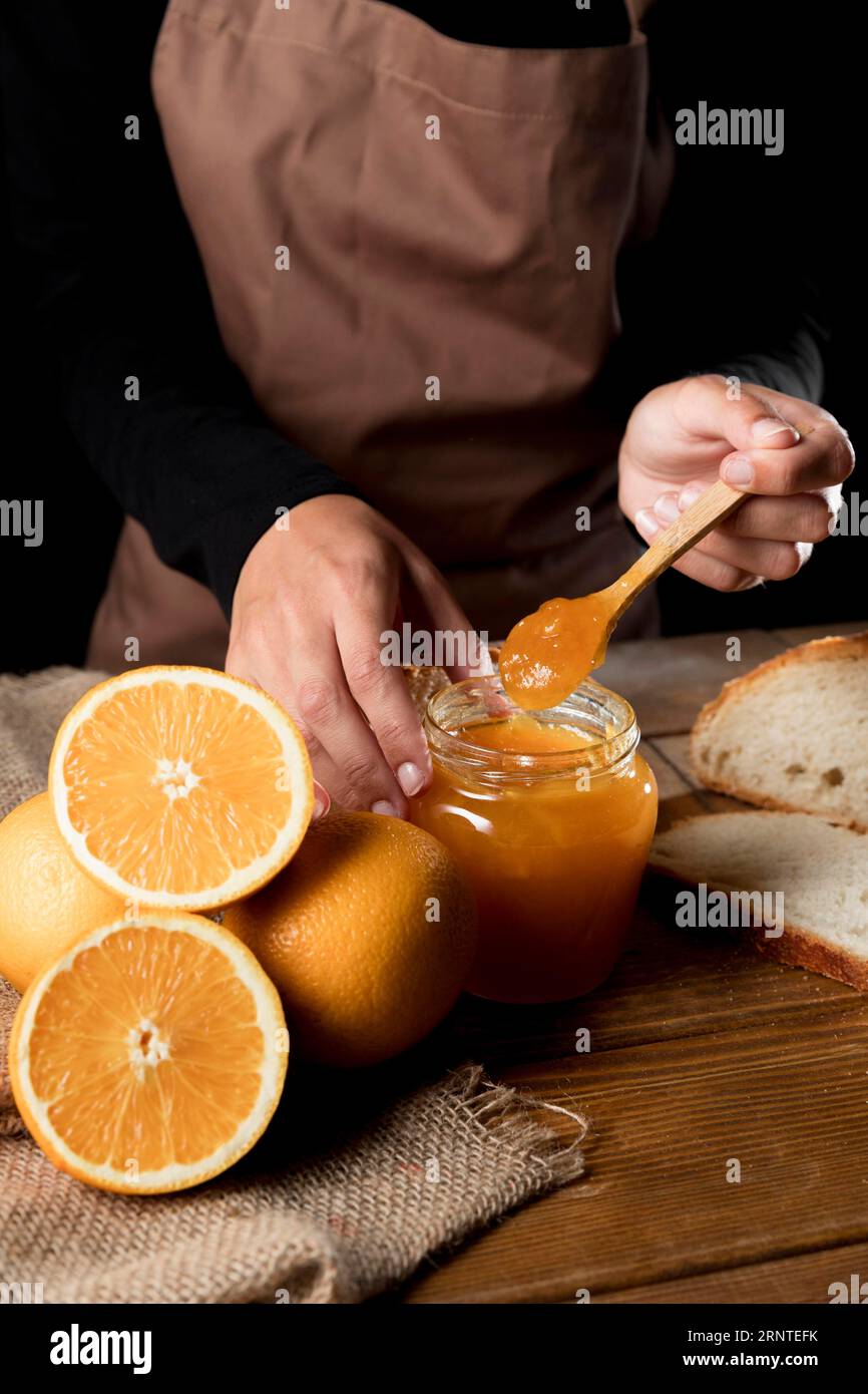 Hochwinkelkoch mit orangefarbener Mnarmalade im Glas Stockfoto