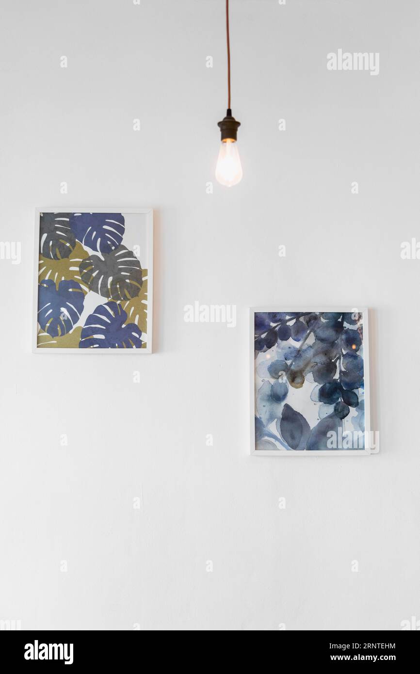 Glühlampe Vorderseite Malerei Bilderrahmen befestigt weiße Wand Stockfoto