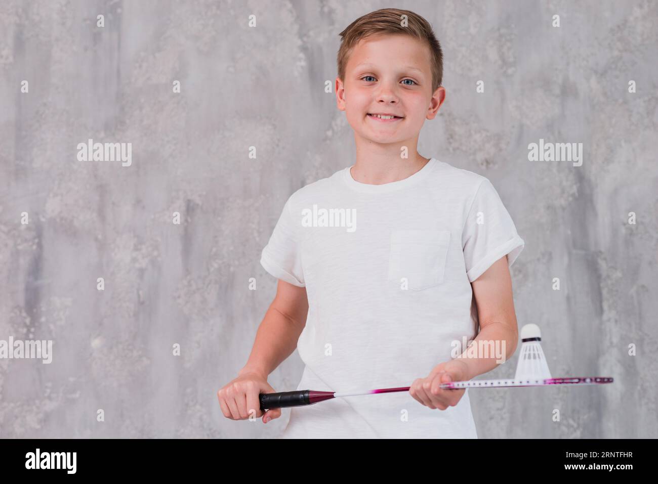 Porträt lächelnder Junge, der eine Kamera hält, die wie ein Schläger aussieht Stockfoto