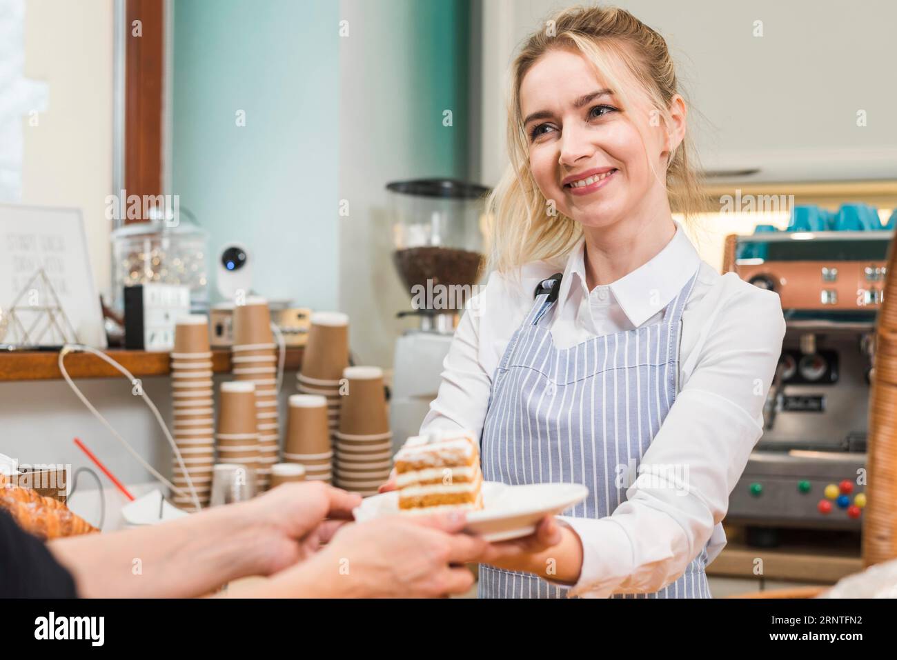 Lächelnde Bäckerin serviert Gebäck Kuchen Kunden Stockfoto