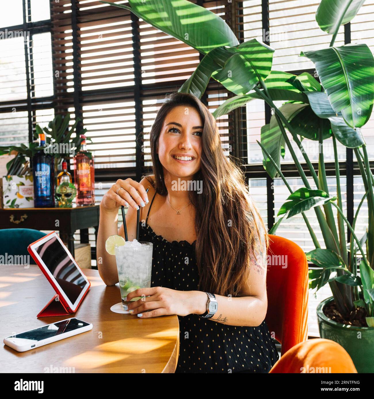 Lächelnde schöne junge Frau mit Cocktail-Smartphone digitalen Tablet-Restaurant Stockfoto