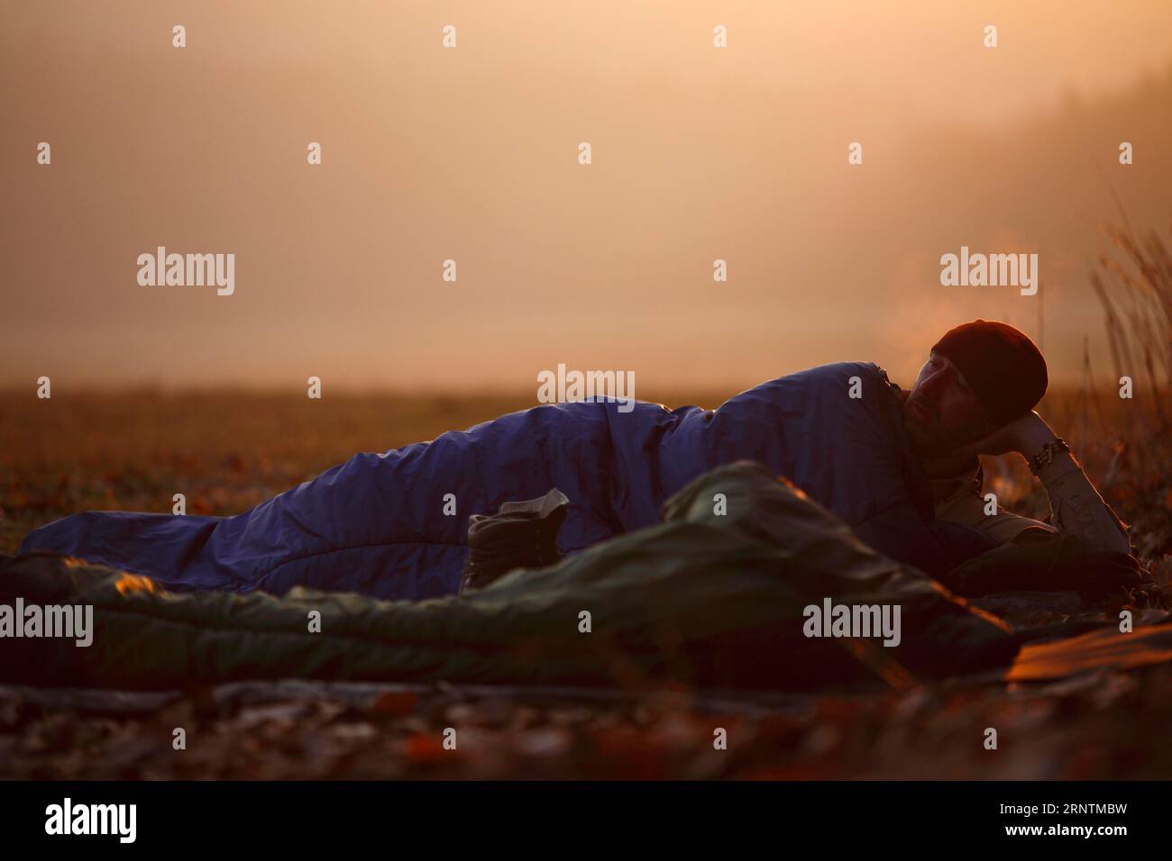 Mann im Schlafsack bei frostigem Wetter, im Freien schlafen, Alltag eines Naturfotografen, Nationalpark Harz, Sachsen-Anhalt, Deutschland Stockfoto