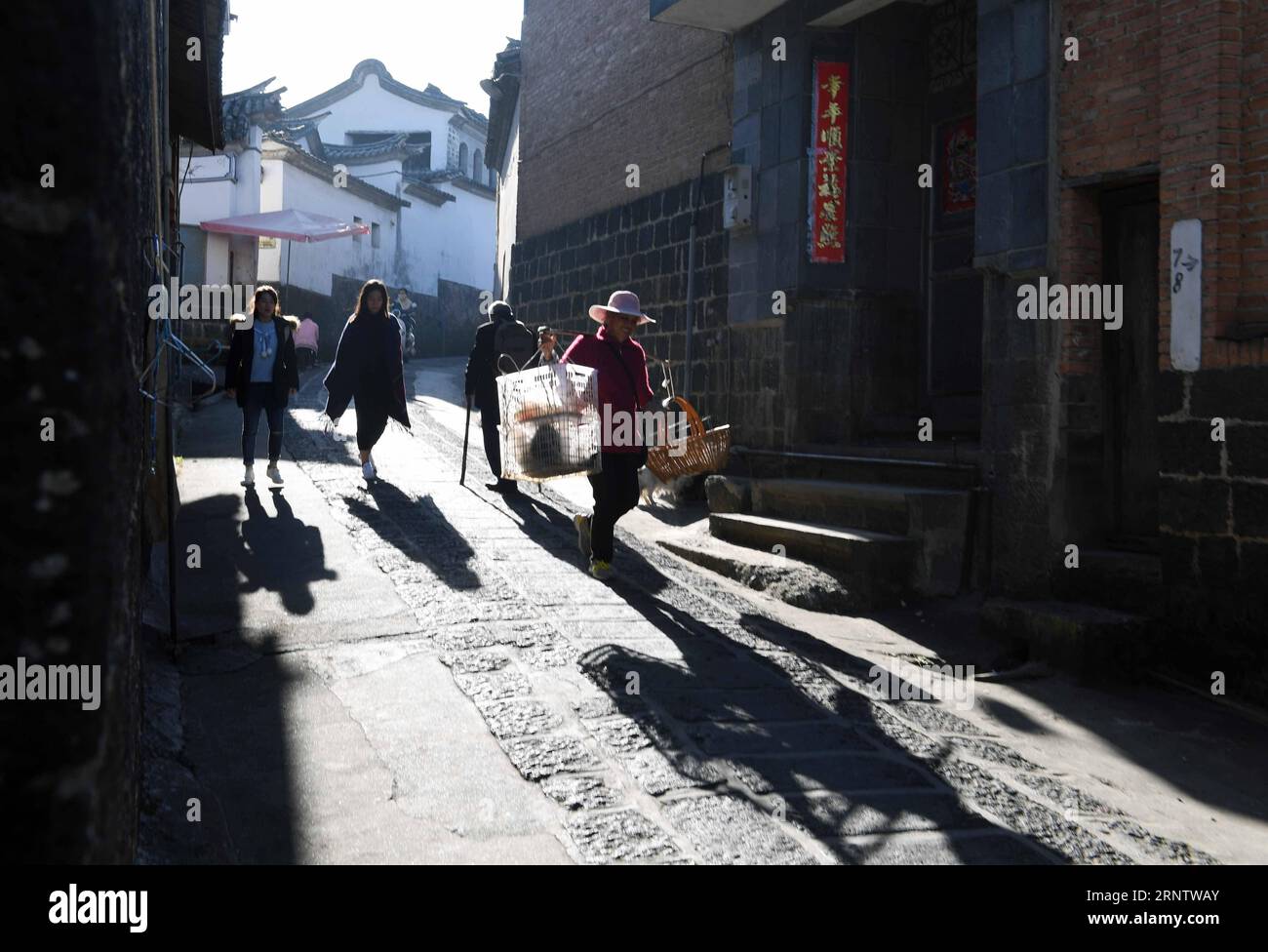 (171120) -- TENGCHONG, 20. November 2017 -- People Walk in Heshun Township of Tengchong County, Südwestchinesische Provinz Yunnan, 19. November 2017. Die Heshun Township liegt in der Provinz West Yunnan und ist eine kleine antike Stadt mit angenehmem Klima und ruhiger Umgebung. So klein es auch ist, die Stadt ist in vielerlei Hinsicht ein charmanter Ort. Es war früher ein wichtiger Halt auf der alten South Silk Road, wo die chinesische Kultur mit der Südostasiens und des Westens zusammenkam. Die Stadt zeigt ein harmonisches Bild der Natur und der Menschen mit blühenden cole-Feldern, immergrünen Hügeln und altmodischen Dwellin Stockfoto
