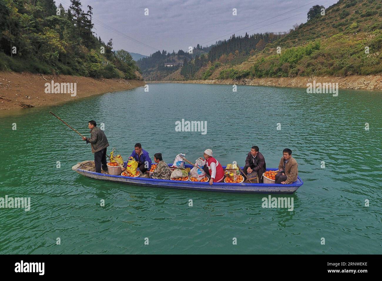 (171217) -- RONGJIANG, 17. Dezember 2017 -- Dorfbewohner nehmen ein Fährboot mit frisch geernteten Nabelorangen in Rongjiang County von Miao-Dong Autonome Präfektur Qiandongnan, Südwestchinesische Provinz Guizhou, 17. Dezember 2017. ) (wf) CHINA-GUIZHOU-ORANGES-HARVEST (CN) LiuxXu PUBLICATIONxNOTxINxCHN Stockfoto