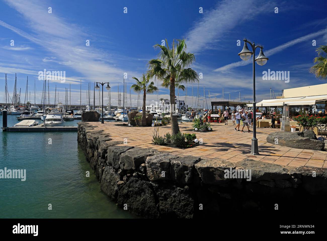Entspannte Szene im Marina Rubicon mit Touristen, verschiedenen Cafés und Bars. Playa Blanca, Lanzarote, Kanarische Inseln, Spanien. Stockfoto