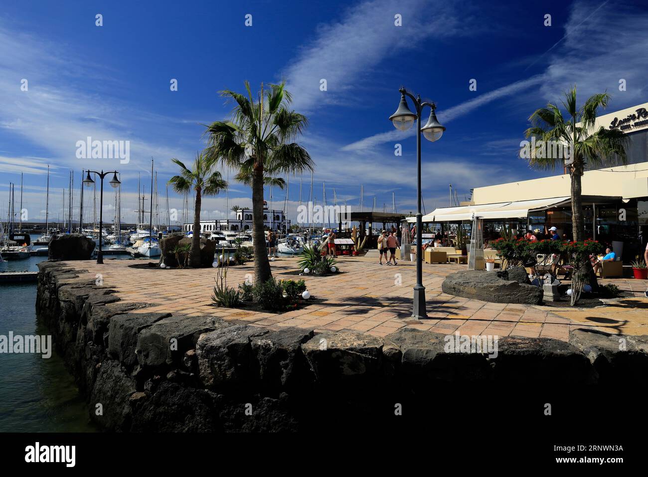 Entspannte Szene im Marina Rubicon mit Touristen, verschiedenen Cafés und Bars. Playa Blanca, Lanzarote, Kanarische Inseln, Spanien. Stockfoto