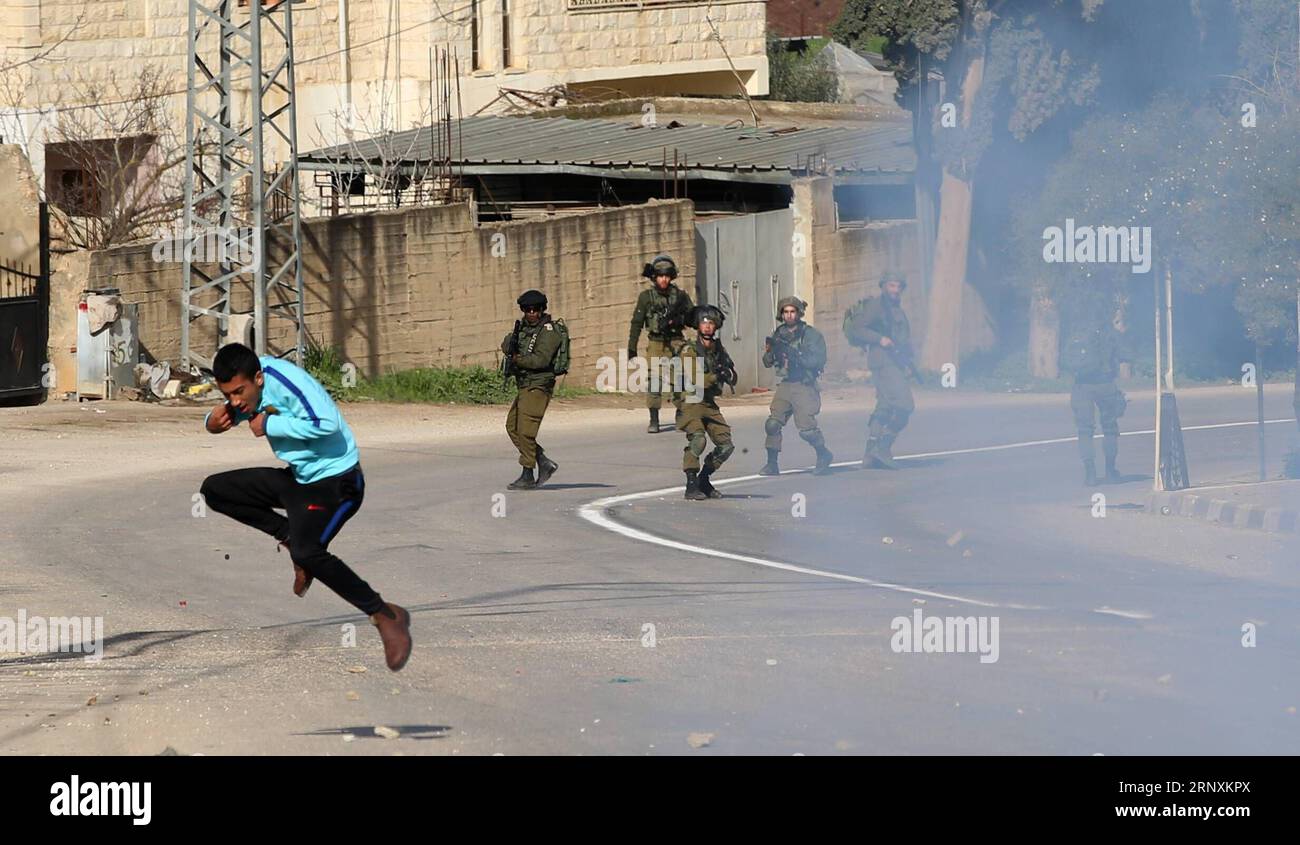 (180204) -- JENIN, 4. Februar 2018 -- Ein palästinensischer Demonstrant läuft, um sich vor Tränengas zu verstecken, das von israelischen Soldaten während der Zusammenstöße während einer angeblich israelischen Suchoperation im Westjordanland-Dorf al-Kufer in der Nähe der Stadt Jenin am 3. Februar 2018 gefeuert wurde. In der Gegend gibt es regelmäßige Zusammenstöße zwischen lokalen Palästinensern und israelischen Streitkräften wegen Protesten gegen nahe gelegene jüdische Siedlungen.Ayman Nobani) (wh) MIDEAST-JENIN-CLASHES zhaoyue PUBLICATIONxNOTxINxCHN Stockfoto