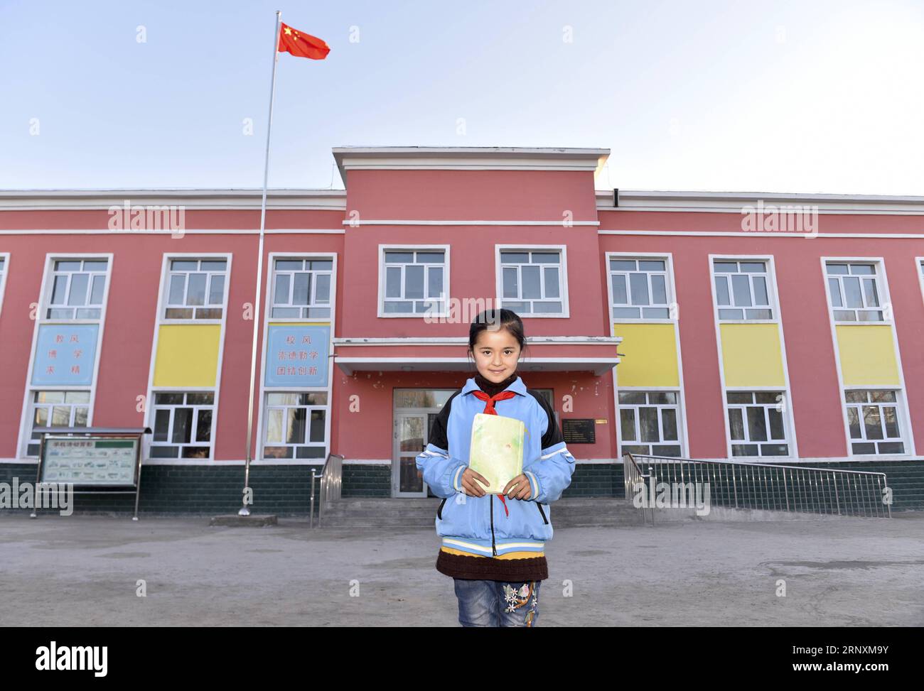 (180204) -- PEKING, 4. Februar 2018 -- Ein Mädchen aus Klasse 3, Klasse 2 einer Dorfgrundschule posiert für Bilder vor dem Schulgebäude im Dorf Gaimai im Bezirk Yining, Nordwestchina, autonome Region Xinjiang Uygur, 22. November 2017. Sie und ihre Schulkameraden genossen das neue Klassenzimmer-Gebäude, das Ende 2015 fertiggestellt wurde. Sie wollte in Zukunft Ärztin werden, um ihrer Heimatstadt zu dienen. Li Yuanmin, ein Delegierter des 19. Nationalkongresses der Kommunistischen Partei Chinas (KPCh), diente als Dorfsekretär der Partei. Sie hat große Anstrengungen unternommen, um den Weg der Party zu propagieren, Guidelin Stockfoto