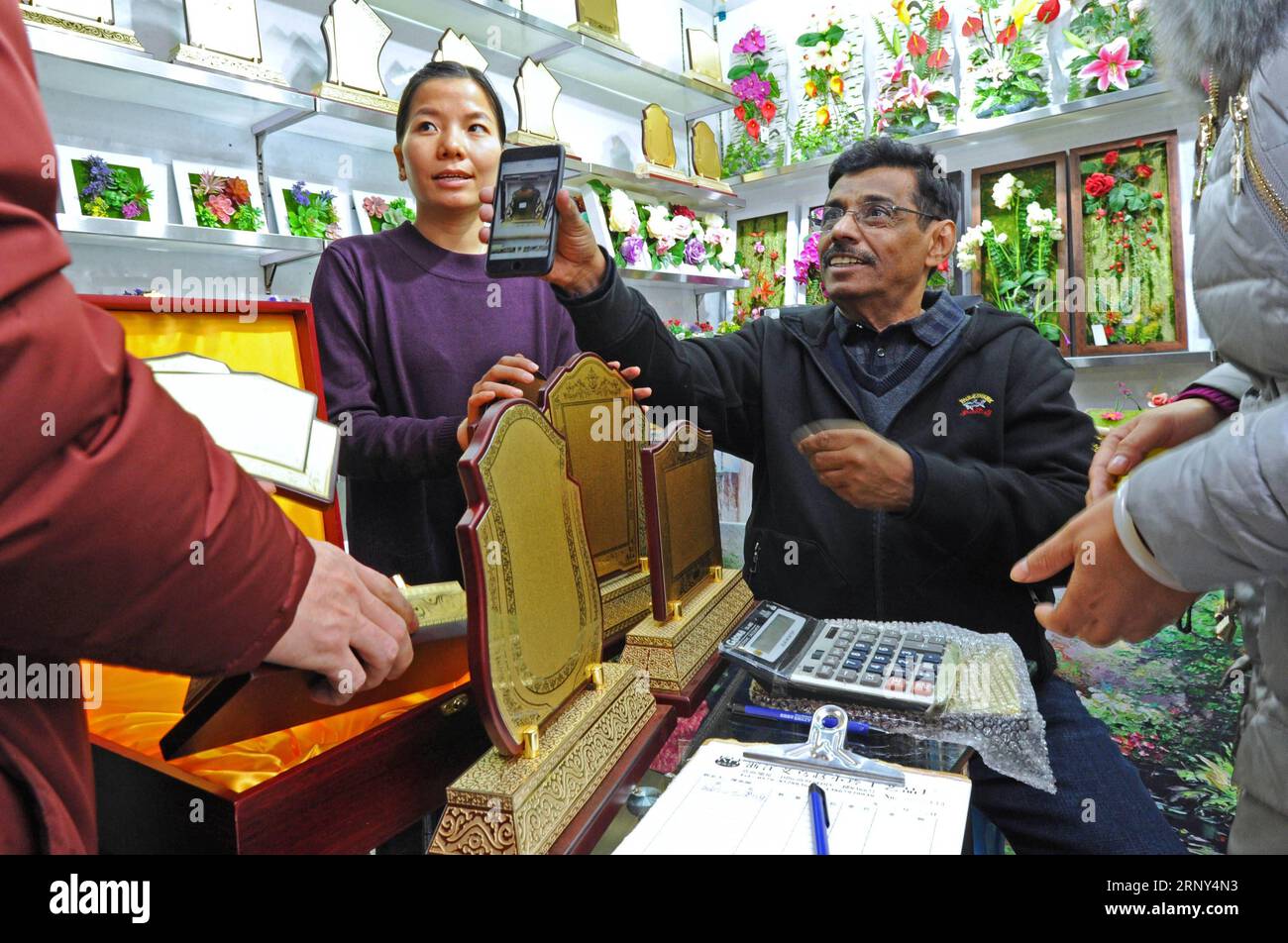 (180227) -- YIWU, 27. Februar 2018 -- Ein Geschäftsmann (1st R) aus den Vereinigten Arabischen Emiraten (VAE) zeigt Proben für Händler in China Commodities City in Yiwu, einer Stadt, die auf den Handel mit Kleinwaren in der ostchinesischen Provinz Zhejiang spezialisiert ist, 23. Dezember 2017. Die China Commodities City in Yiwu erreichte 2017 ein Handelsvolumen von 122,6 Milliarden Yuan (etwa 19,4 Milliarden US-Dollar), das laut neuesten Statistiken um 10,9 Prozent im Vergleich zum Vorjahr gestiegen ist. ) (Ry) CHINA-YIWU-WARENHANDELSVOLUMEN (CN) TanxJin PUBLICATIONxNOTxINxCHN Stockfoto