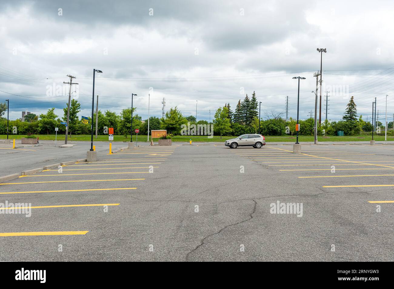 Einsames Auto auf einem großen Parkplatz geparkt. Stockfoto