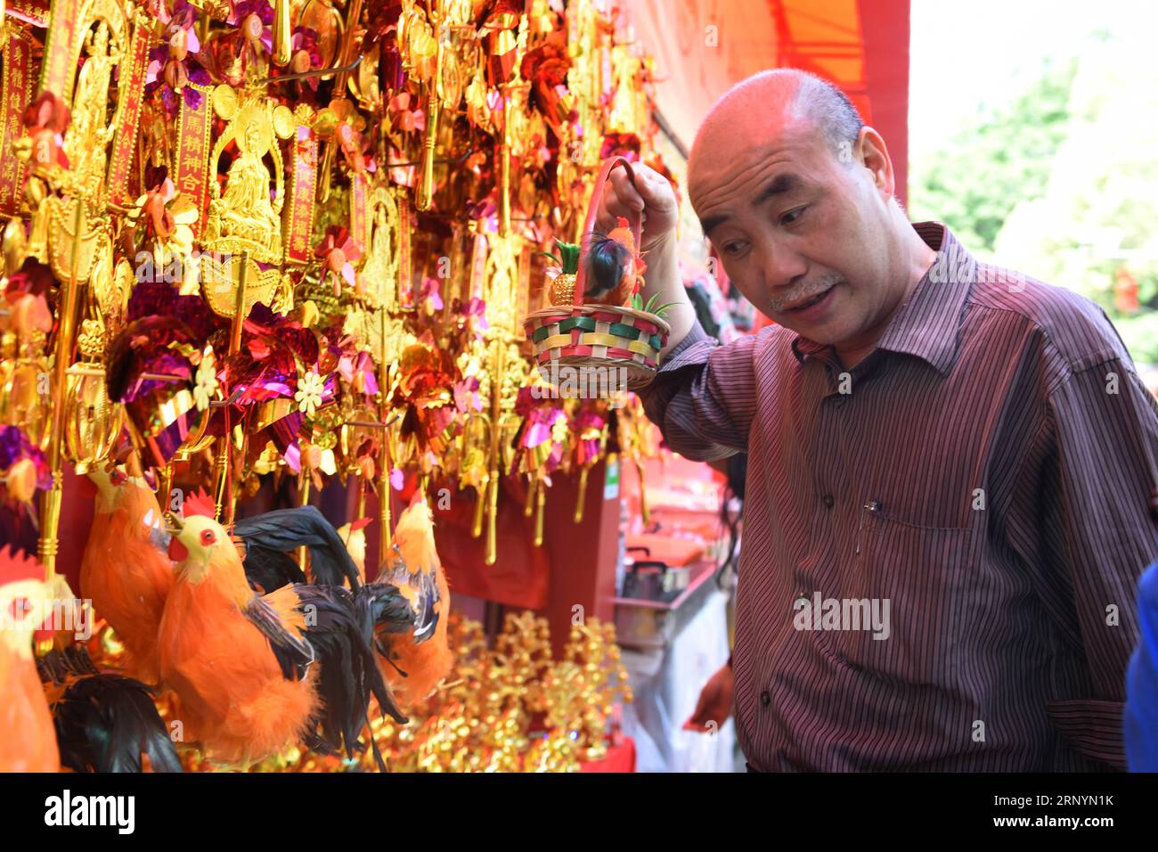 (180327) -- GUANGZHOU, 27. März 2018 -- Ein Mann kauft Souvenirs auf einer Tempelmesse in Guangzhou, südchinesische Provinz Guangdong, 27. März 2018. Das 14. Guangzhou Folk Cultural Festival, auch die Boluodan Temple Fair, begann am Dienstag im Huangpu District der Stadt. )(mcg) CHINA-GUANGZHOU-TEMPLE FAIR (CN) LuxHanxin PUBLICATIONxNOTxINxCHN Stockfoto