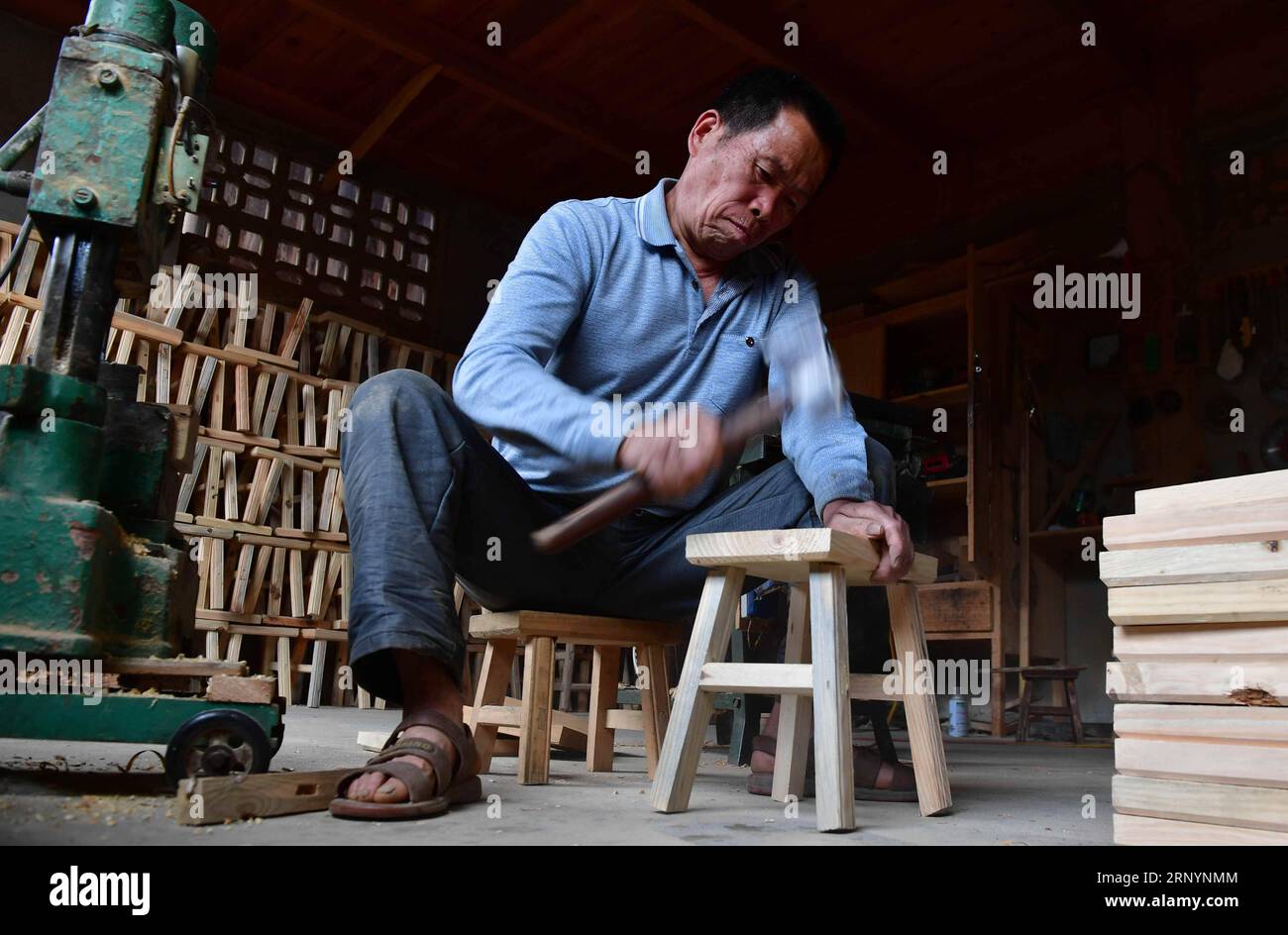 (180328) -- RONGSHUI, 28. März 2018 -- Wu Mingxin macht Hocker in der Gandong Township des Rongshui Miao Autonomous County, südchinesische autonome Region Guangxi Zhuang, 27. März 2018. Wu Mingxin ist Stuhlbauer und hat in den letzten Jahren die steigende Nachfrage nach Hockern in den Dörfern beobachtet. Das Leben der Dorfbewohner im autonomen Kreis Rongshui Miao wurde seit der Armutsbekämpfung verbessert. Eine offensichtliche Veränderung in ihren Familien ist der erhöhte Hocker, da mehr Hocker benötigt werden, wenn sie große Feiern abhalten, um Freunde und Besucher zu unterhalten. )(WSW) CHINA-GUANGXI-POV Stockfoto