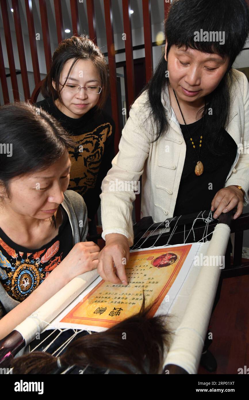 (180413) -- NANCHANG, 13. April 2018 -- die Handwerkerin Tao Yonghong (R) unterrichtet Studenten, die Haarstickereien in Nanchang, der Hauptstadt der ostchinesischen Provinz Jiangxi, herstellen, 13. April 2018. Die Haarstickerei, die mehr als 500 Jahre Geschichte hat, ist als immaterielles Kulturerbe der Provinz aufgeführt. Wie der Name schon sagt, verwendet die Haarstickerei menschliches Haar als Garn. Da Chinesen im Allgemeinen schwarzes Haar haben, wird es auch Moxiu (schwarze Stickerei) genannt. (Lb) CHINA-JIANGXI-HAIR STICKEREI (CN) SongxZhenping PUBLICATIONxNOTxINxCHN Stockfoto