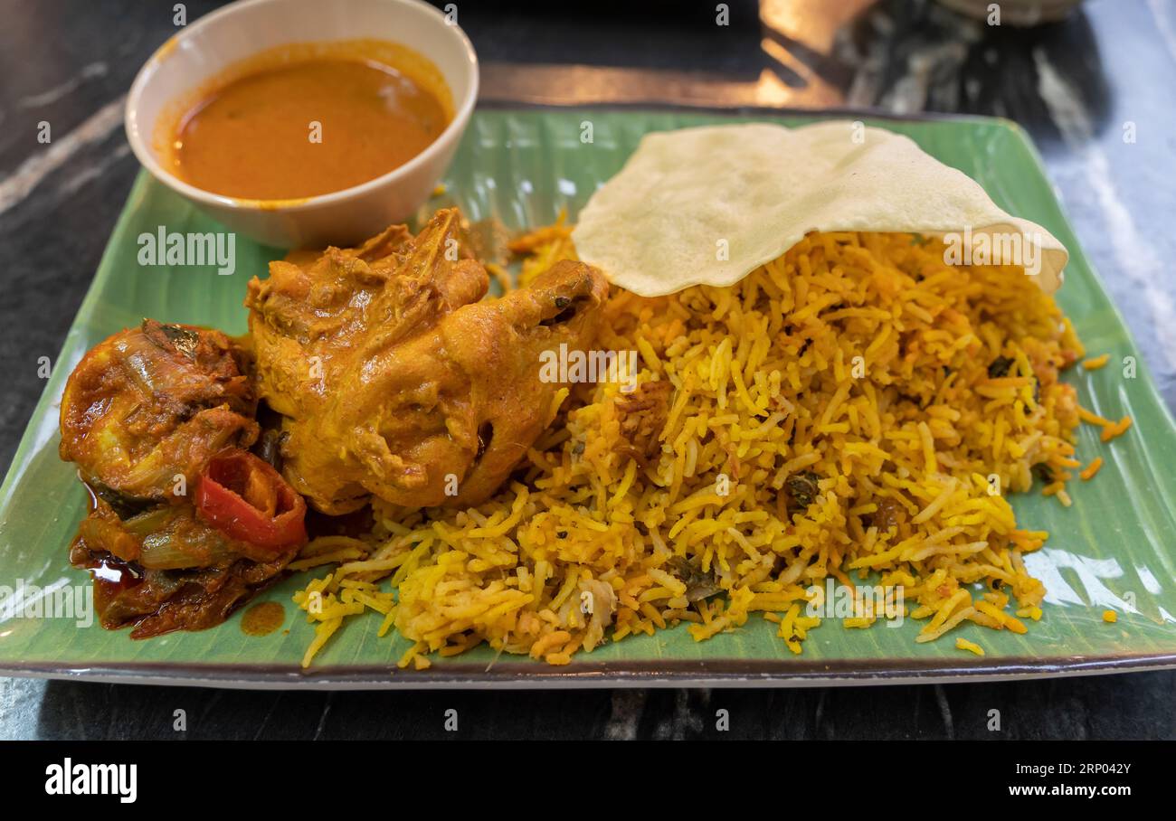 Nahansicht des Biryani-Reises mit Curryhähnchen und Papadam Stockfoto
