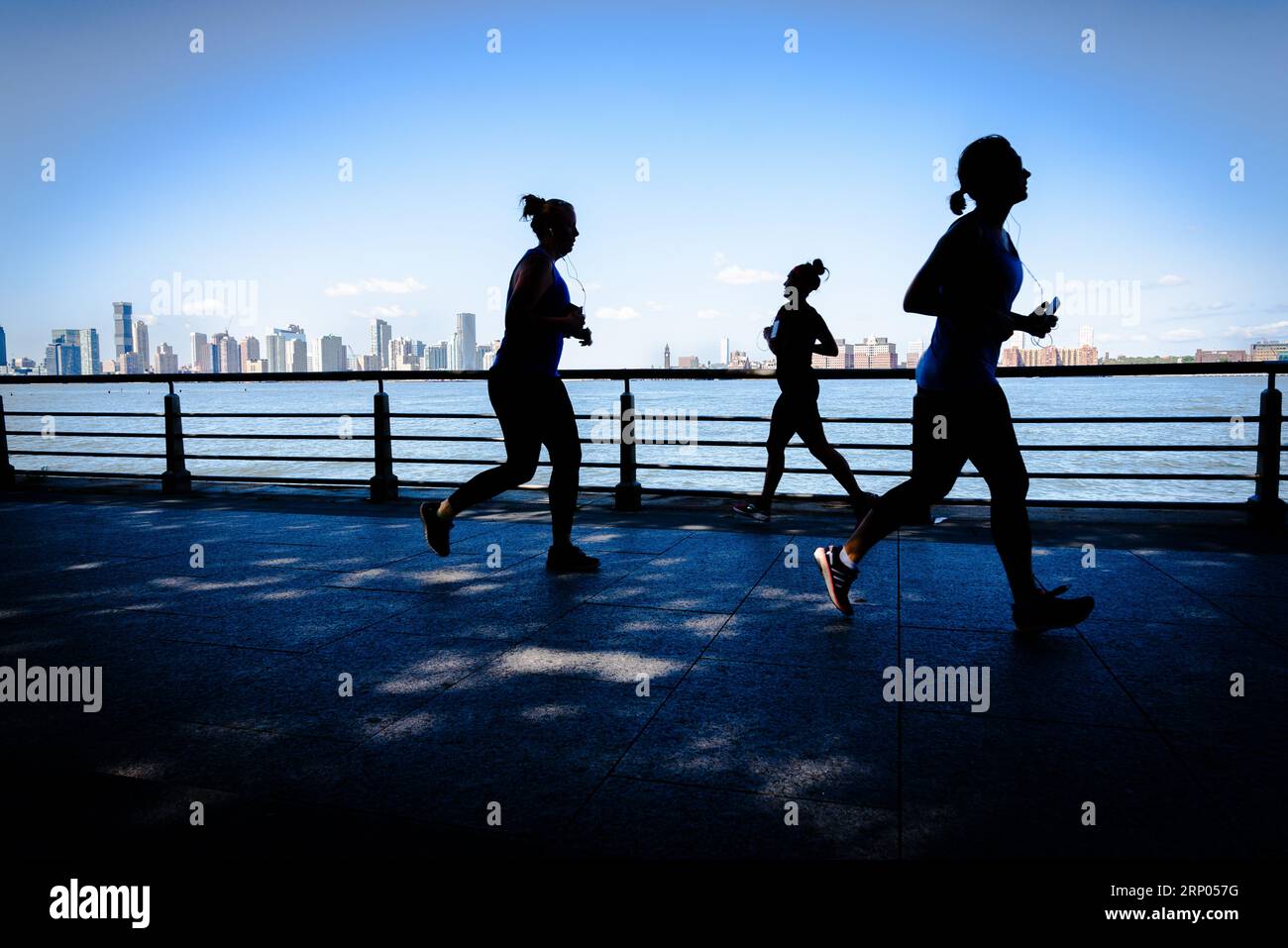 Silhouetten entlang des Hudson River auf dem Hudson River Greenway in Manhattan, New York, USA. Stockfoto