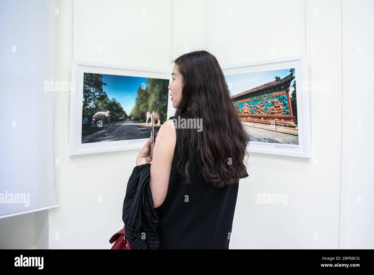 (180425) -- ATHEN, 25. April 2018 -- Eine Frau besucht am 24. April 2018 die Fotoausstellung griechische Fotografen mit Schwerpunkt Peking im Hafen von Piräus, Griechenland. Der Hafen von Piräus hat die Chinesen in den letzten Jahren herzlich begrüßt und ist zu einem starken Symbol für chinesisch-griechische Freundschaft und Zusammenarbeit geworden. Daher veranstaltet der Hafen vom 24. April bis 4. Mai eine Fotoausstellung griechischer Fotografen, die sich auf Peking konzentriert, um Griechen näher an Chinas Hauptstadt zu bringen. ) GRIECHENLAND-PIRÄUS HAFEN-CHINA-PEKING-FOTOAUSSTELLUNG LEFTERISXPARTSALIS PUBLICATIONXNOTXINXCHN Stockfoto