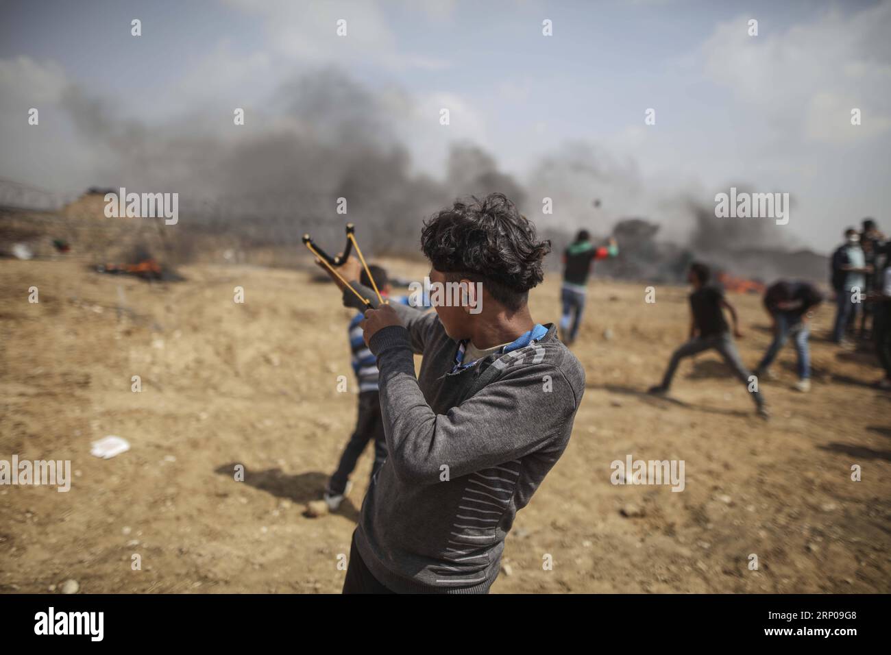 (180427) -- GAZA, 27. April 2018 -- Ein palästinensischer Demonstrant verwendet eine Schleuder, um Steine während der Zusammenstöße mit israelischen Truppen an der Grenze zwischen Gaza und Israel, östlich von Gaza-Stadt, am 27. April 2018 zu schleudern. Drei Palästinenser wurden getötet und 350 weitere verwundet am Freitag während der Zusammenstöße zwischen Dutzenden palästinensischen Demonstranten und israelischen Soldaten im östlichen Gazastreifen, sagten Sanitäter. MIDEAST-GAZA-KONFLIKTE WissamxNassar PUBLICATIONxNOTxINxCHN Stockfoto