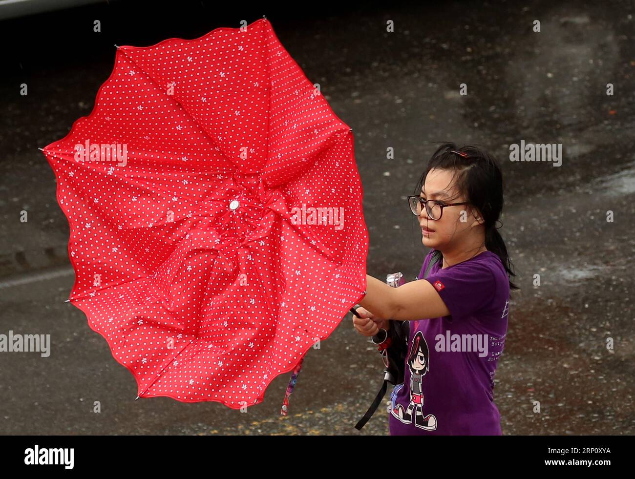 (180529) -- , Mai 29, 2018 -- Eine Frau hält am 29. Mai 2018 in Myanmar einen Regenschirm gegen den starken Wind. Myanmars Abteilung für Meteorologie und Hydrologie gab am Dienstag eine Notfallwarnung mit rotem Code heraus, dass eine tiefe Depression über dem mittleren Osten der Bucht von Bengalen auftritt und der Wirbelsturm in den nächsten 12 Stunden in Küstengebieten des Bundesstaates Rakhine landen wird. U Aung) (dtf) MYANMAR--KLEINE ZYKLONWARNUNG yangon PUBLICATIONxNOTxINxCHN Stockfoto