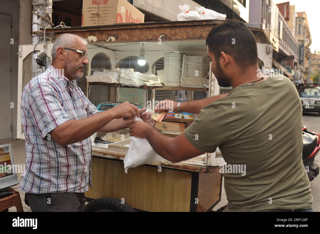 (180605) -- TRIPOLI, 5. Juni 2018 -- Ein Mann kauft Al-Shmisa Sweet in Tripoli, Libanon, 4. Juni 2018. Al-Shmisa-Süßes oder Creme-Donut ist eine der beliebtesten Süßwaren, die nur im libanesischen Tripoli zu finden sind. Diese Art von Süßes wird nur von der Familie al-Haddad hergestellt, deren Söhne diesen Beruf jahrzehntelang erbten. ) (lrz) LEBANON-TRIPOLI-CREAM DONUT Khalid PUBLICATIONxNOTxINxCHN Stockfoto