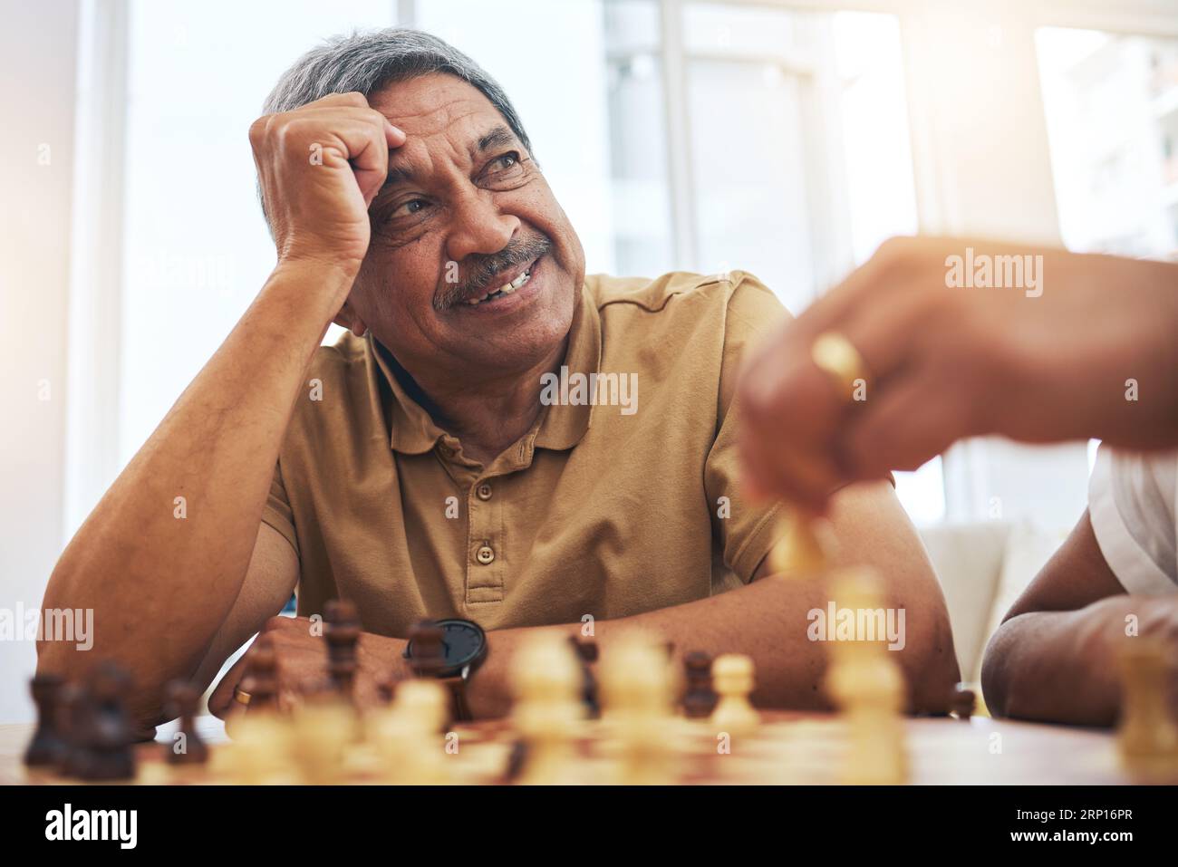 Senior man, zu Hause und Schach für Wettbewerb, Spiel und Strategie mit Freund für Konzentration und Entspannung im Wohnzimmer. Denken, Senioren und Menschen mit Pension Stockfoto