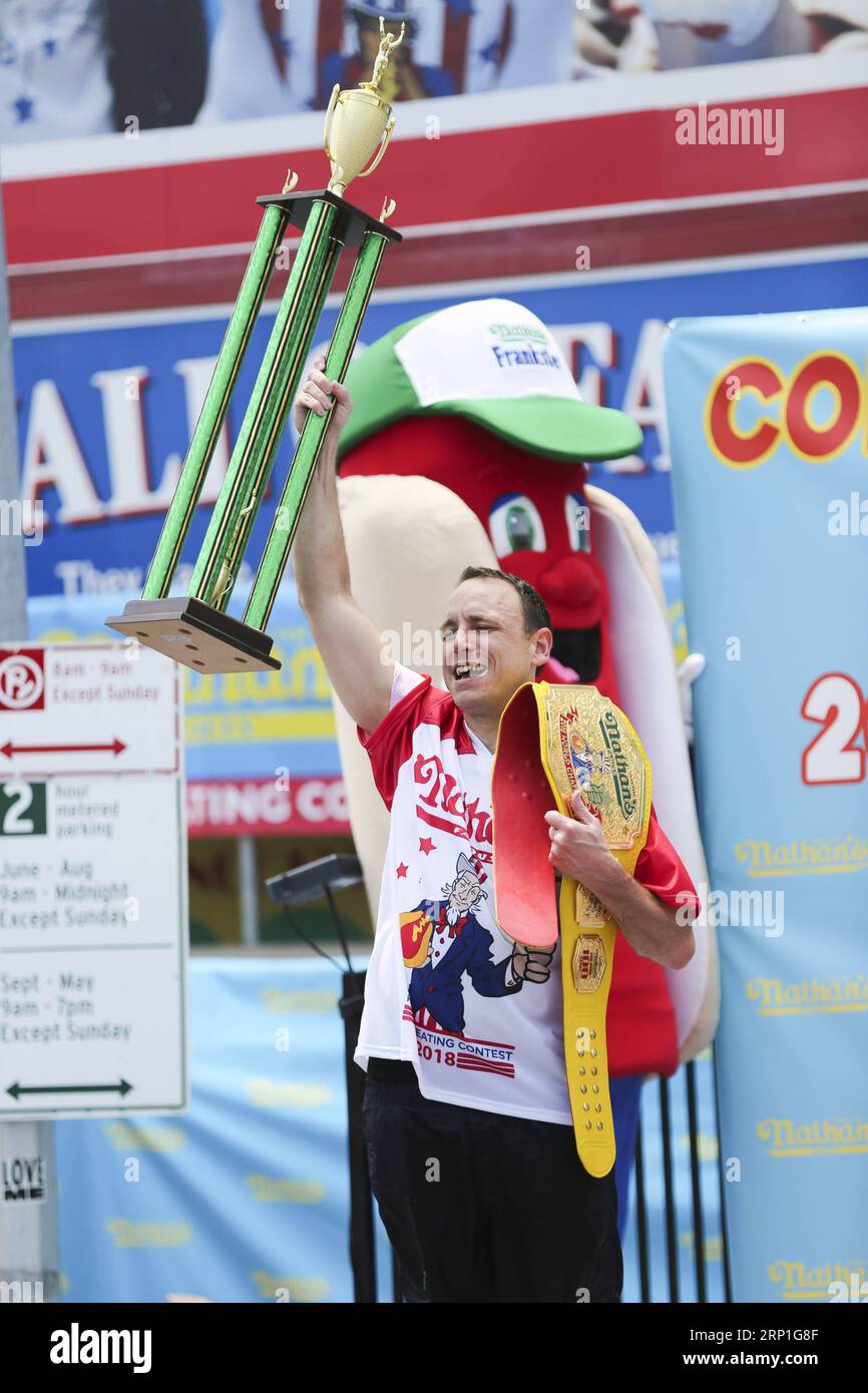 (180704) -- NEW YORK, 4. Juli 2018 -- Joey Chestnut feiert, nachdem er am 4. Juli 2018 den Männerwettbewerb des Nathan s Hot Dog Eating Contest auf Coney Island in New York, USA, gewonnen hat. Joey Chestnut stellte am Mittwoch einen neuen Weltrekord auf, indem er 74 Hot Dogs in 10 Minuten beim Nathan's Hot Dog Eating Contest in New York verschluckte. Miki Sudo verteidigte den Titel der Frauen, indem er 37 Hot Dogs in 10 Minuten aß. )? U.S.-NEW YORK-HOT DOG EATING CONTEST WANGXYING PUBLICATIONXNOTXINXCHN Stockfoto