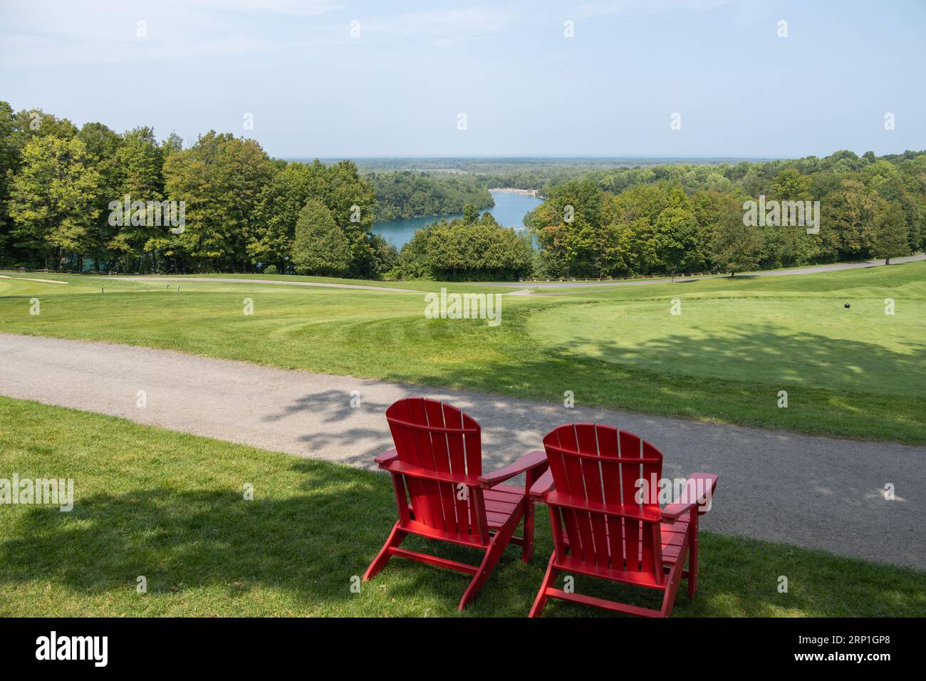 Blick auf die Green Lakes in Syrakus vom Golfplatz. Blick auf den See mit 2 roten Liegestühlen im Vordergrund. Keine Personen. Stockfoto