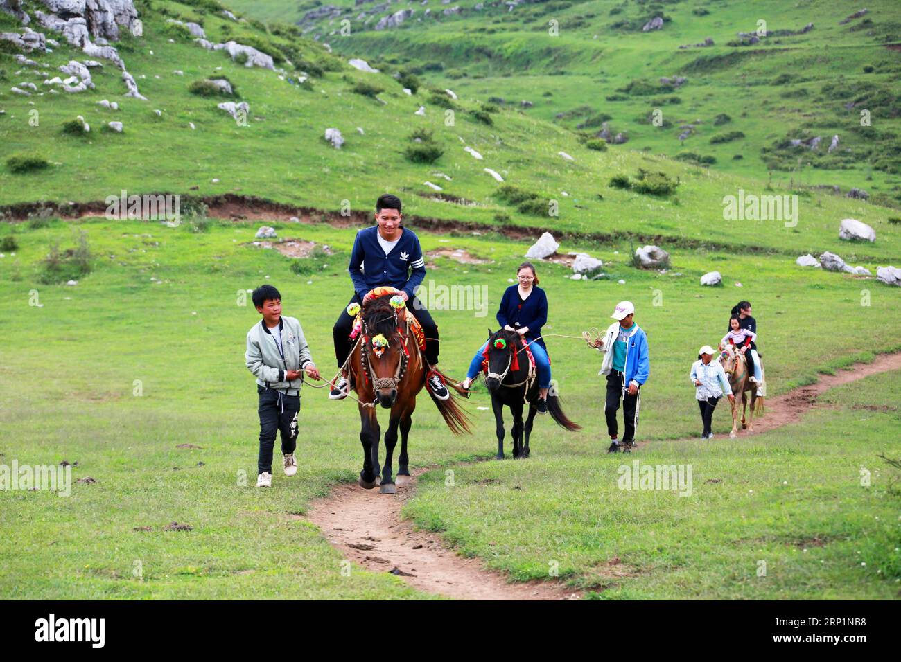 (180716) -- BIJIE, 16. Juli 2018 (Xinhua) -- Touristen reiten Pferde auf der Baicaoping Meadow im Weining County, südwestchinesische Provinz Guizhou, 15. Juli 2018. (Xinhua/He Huan) (hxy) CHINA-SUMMER VACATION-TOURISM (CN) PUBLICATIONxNOTxINxCHN Stockfoto