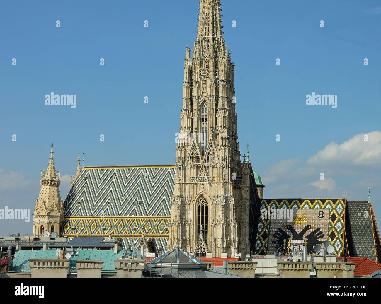 Glockenturm und Dach des Stephansdoms in Wien in Österreich und Doppeladler-Kaiseremblem mit dem Habsburg-Lothringen-Wappen Stockfoto