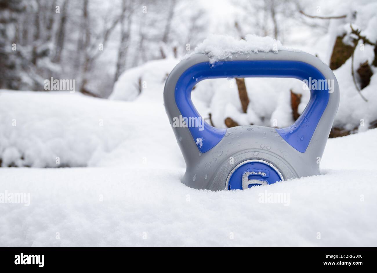 Kettlebell im Tiefschnee. Gesunde Fitness Lifestyle Winterzusammensetzung. Gym-Workout, Sporttrainingskonzept. Training bei kaltem Wetter. Stockfoto