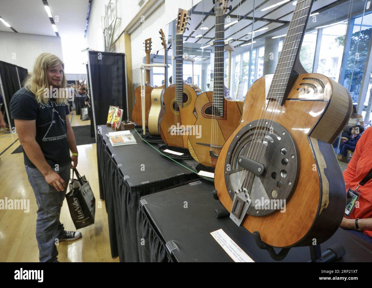 (180812) -- VANCOUVER, 12. August 2018 -- Ein Besucher schaut sich einige Gitarren an, die beim jährlichen Vancouver International Guitar Festival in Vancouver, Kanada, am 11. August 2018 gezeigt werden. Das 2-tägige Vancouver International Guitar Festival begann am Samstag mit einer Ausstellung von Instrumenten, die von Gitarrenbauern aus der ganzen Welt gezeigt wurden. ) (Qxy) KANADA-VANCOUVER-INTERNATIONALES GITARRENFESTIVAL LiangxSen PUBLICATIONxNOTxINxCHN Stockfoto