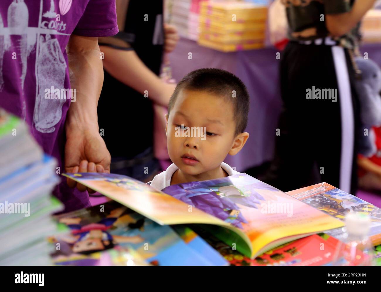 (180815) -- SHANGHAI, 15. August 2018 -- Ein Kind liest ein Buch auf der Shanghai Book Fair 2018 in Shanghai, Ostchina, 15. August 2018. Insgesamt wurden 150.000 Arten von Büchern ausgestellt und mehr als 500 Verlage nahmen an der siebentägigen Buchmesse Teil, die am Mittwoch begann. ) (Hxy) CHINA-SHANGHAI-BOOK FAIR (CN) LiuxYing PUBLICATIONxNOTxINxCHN Stockfoto