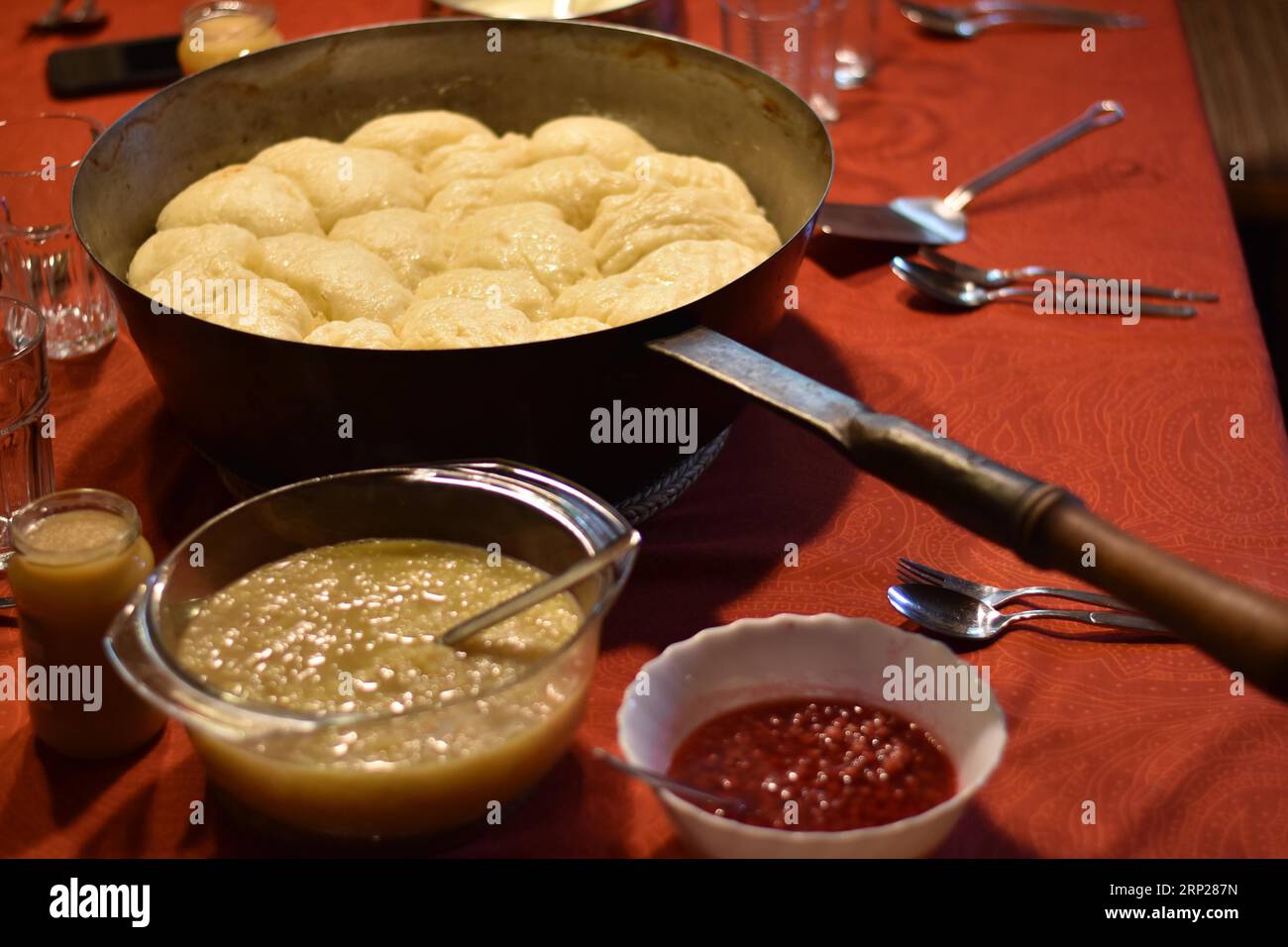 Dampfnudeln in rustikaler alter Dampfnudelpfanne mit Apfelsauce und ...