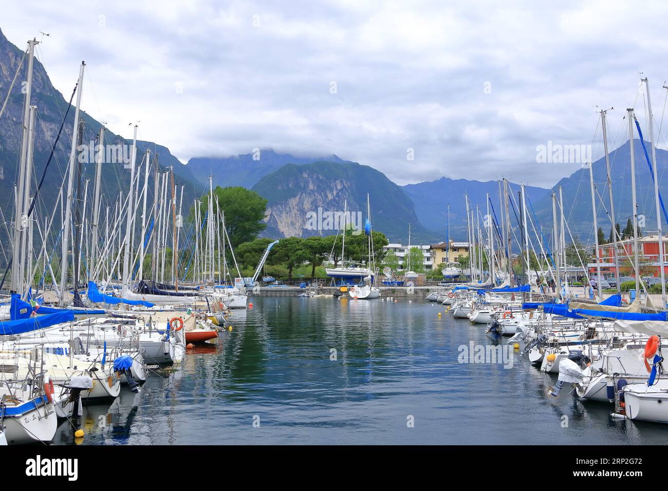 Mai 19 2023 - Riva del Garda in Italien: Menschen am Hafen der Stadt an einem bewölkten Tag Stockfoto